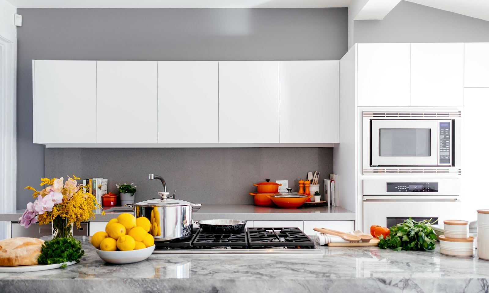 A calm kitchen with wooden cabinets and a bowl of fruit